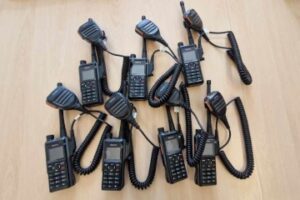 Siedem nowoczesnych zestawów radiotelefonów Hytera HP685, ułożonych na stole w remizie OSP Warszawa – Białołęka.